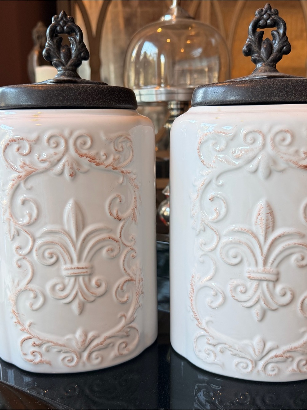Two Decorative Fleur-de-Lis Ceramic Canisters with Bronze Lids - White